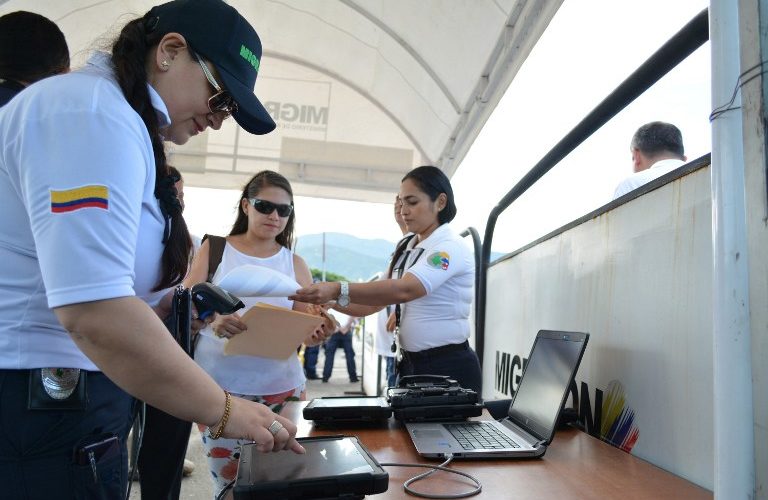 A Colombian migration staffer checks the new Border Migration Card (TMF) to a Venezuelan citizen near the Simon Bolivar international bridge, on the Venezuelan-Colombian border, in Cucuta, Colombia, on May 1, 2017. The TMF is designed to allow Venezuelans to stay for up to eight days in Colombia on a regular basis and only applies to residents of 10 border areas in order to speed up the passage of those who usually cross from one country to the other. / AFP PHOTO / SCHNEYDER MENDOZA
