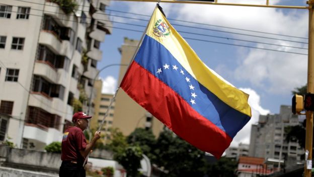 Hombre sosteniendo la bandera de Venezuela en Caracas.